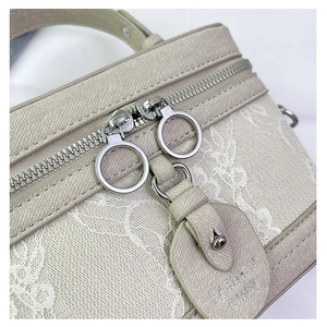 Detail of cross-grain leather box bag with floral lace embroidery and silver ring zipper