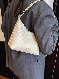 Elegant cream woven bucket bag for women featuring premium leather texture and shoulder strap