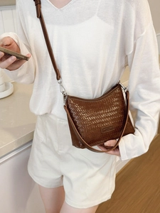 Brown woven leather bucket bag with dual straps for shoulder or crossbody wear