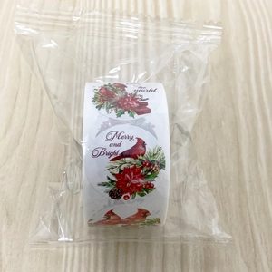Detailed view of Christmas bird round gift stickers roll with Merry and Bright greeting