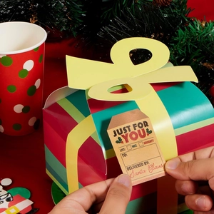 Detail of colorful striped Christmas gift box with yellow bow and festive paper tag