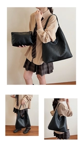 Detail of black woven tote bag and clutch set with matte finish and minimalist strap