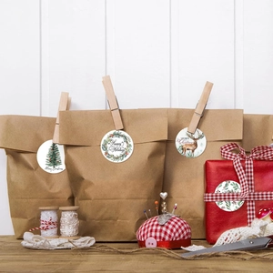 Gros plan d'autocollants de Noël sur des sacs cadeaux avec décorations de fête DIY