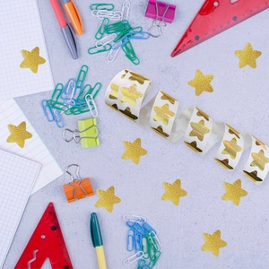 500pcs gold holographic star reward stickers on a roll with office stationery on desk
