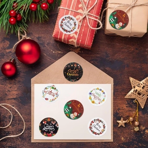 Roll of Christmas stickers with reindeer and snowman designs on wood background