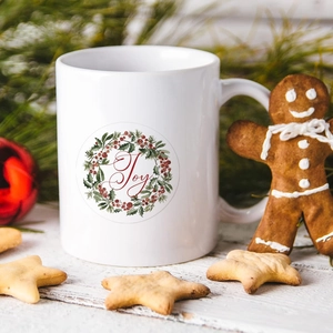 Gros plan d'un mug de Noël en céramique blanche avec motif Joy et biscuits festifs