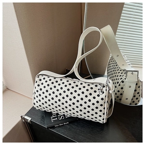 Detail of polka dot pillow bag with white wide shoulder strap and silver hardware