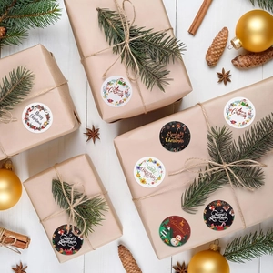 Close-up of Merry Christmas stickers on gift boxes with pine cones and festive decor
