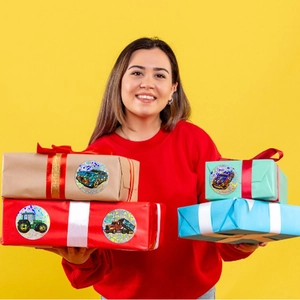 Holographic vehicle stickers on gift boxes held by a person for festive decoration