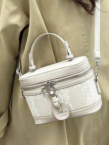 Cream box crossbody bag with floral lace and PU leather on a fashion model