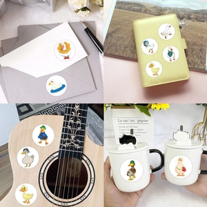 Cartoon duck stickers applied on envelopes, journals, and guitars in creative daily life scenes