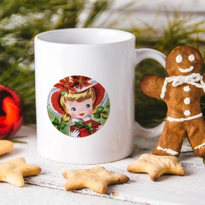 Detail of a white ceramic Christmas mug with a vintage girl illustration and pine needles