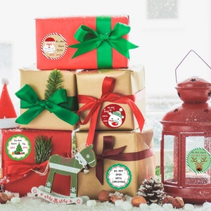 Christmas gift labels with Santa and Reindeer designs on festive red and gold boxes