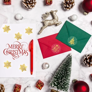 Macro shot of gold foil Christmas stickers on envelopes with festive holiday decor