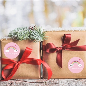 Rainbow thank you stickers on kraft gift boxes with red silk ribbons and cedar branches
