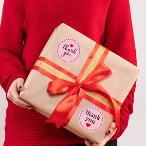 Autocollants Thank You coeur rose sur une boîte cadeau kraft avec rubans rouge et or