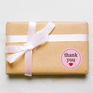 Autocollants de remerciement roses avec cœur sur boîte cadeau dorée et ruban