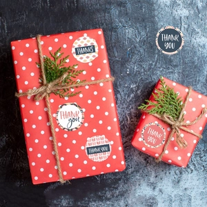 Bohemian thank you stickers on a red polka dot gift box with twine and greenery