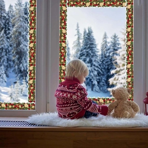 Christmas border stickers with pine branches and red baubles on a cozy winter window