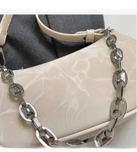Detail of marble pattern on cream shoulder bag with silver chunky chain handle