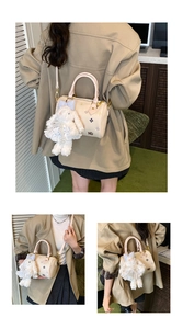 Detail of printed Boston bag with star patterns and a cute plush rabbit pendant charm