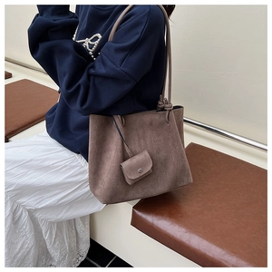 Macro detail of dark brown matte tote bag with matching small coin pouch charm