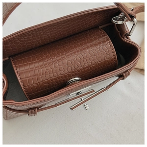 Close-up of brown crocodile texture leather bag showing interior lining and metal lock