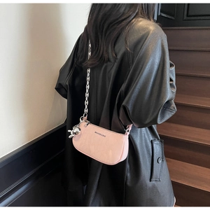 Pink glossy shoulder bag featuring a metal chain strap and a cute balloon dog charm detail