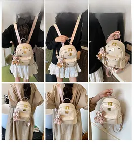 Detailed multi-angle views of a chic off-white leather mini backpack with bear charm