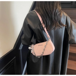 Pink shoulder bag detail with silver chain, rabbit charm and leather texture