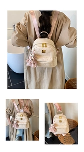 Detail of beige backpack featuring embossed bear patterns and a cute plush toy pendant