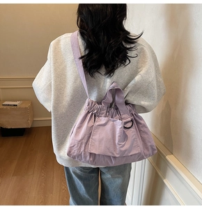 Detail of lavender purple pleated nylon tote bag with large front pocket and D-ring buckle