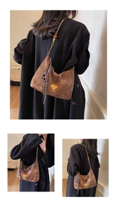 Dettaglio borsa hobo marrone in ecopelle con perla ambrata e ciondolo a corda intrecciata