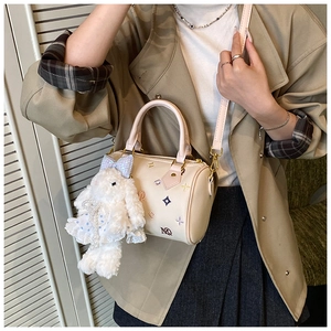 Detail of cream bucket bag with colorful embroidery and cute plush bunny charm
