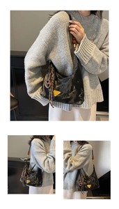Dettaglio borsa hobo nera con logo triangolare giallo e perline color ambra sul manico