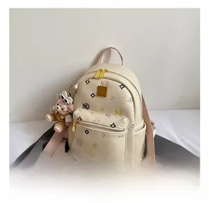 Detail of cream leather backpack with colorful embroidery and plush mascot pendant