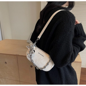 Close-up of white chain shoulder bag with cloud texture and silver balloon dog charm