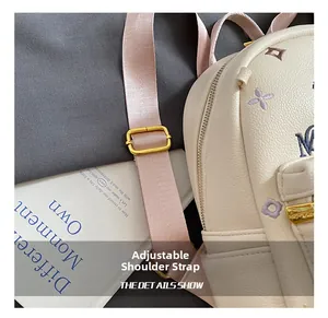 Detail of adjustable pink fabric strap with gold buckle on embroidered backpack