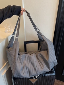 Große dunkelgraue Falten-Tote Bag mit verstellbarem Gurt auf einem Koffergriff platziert