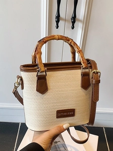 Bamboo handle straw bucket bag with brown leather trim and adjustable crossbody strap