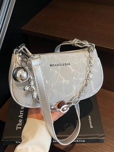 Silver chain shoulder bag with marble texture and balloon dog charm in hand display