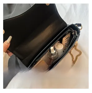 Vue de dessus de l'intérieur du sac en cuir noir montrant les compartiments pour cosmétiques