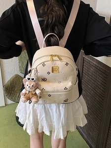 Beige faux leather backpack with colorful embroidery and a plush bear pendant