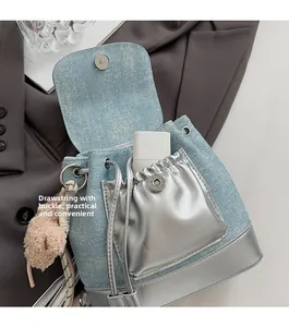 Détail d'un sac à dos en jean avec garniture argentée pailletée et fermeture à cordon