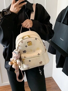 Chic cream monogram backpack with colorful patterns and metallic gold hardware details
