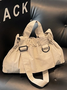 Large beige pleated nylon tote bag with adjustable black shoulder strap for daily commuting