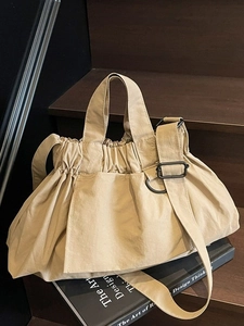 Large khaki nylon tote bag with drawstring closure and adjustable crossbody shoulder strap