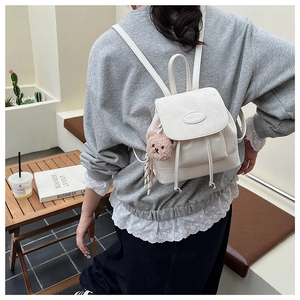 Détail du mini sac à dos blanc en cuir PU avec fermeture à cordon et pendentif ours