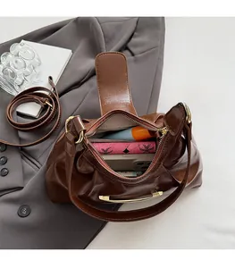 Interior view of brown faux leather crescent bag showing ample storage for phone and wallet