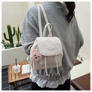 Détail du sac à dos en cuir PU crème avec cordon de serrage et pendentif ours mignon